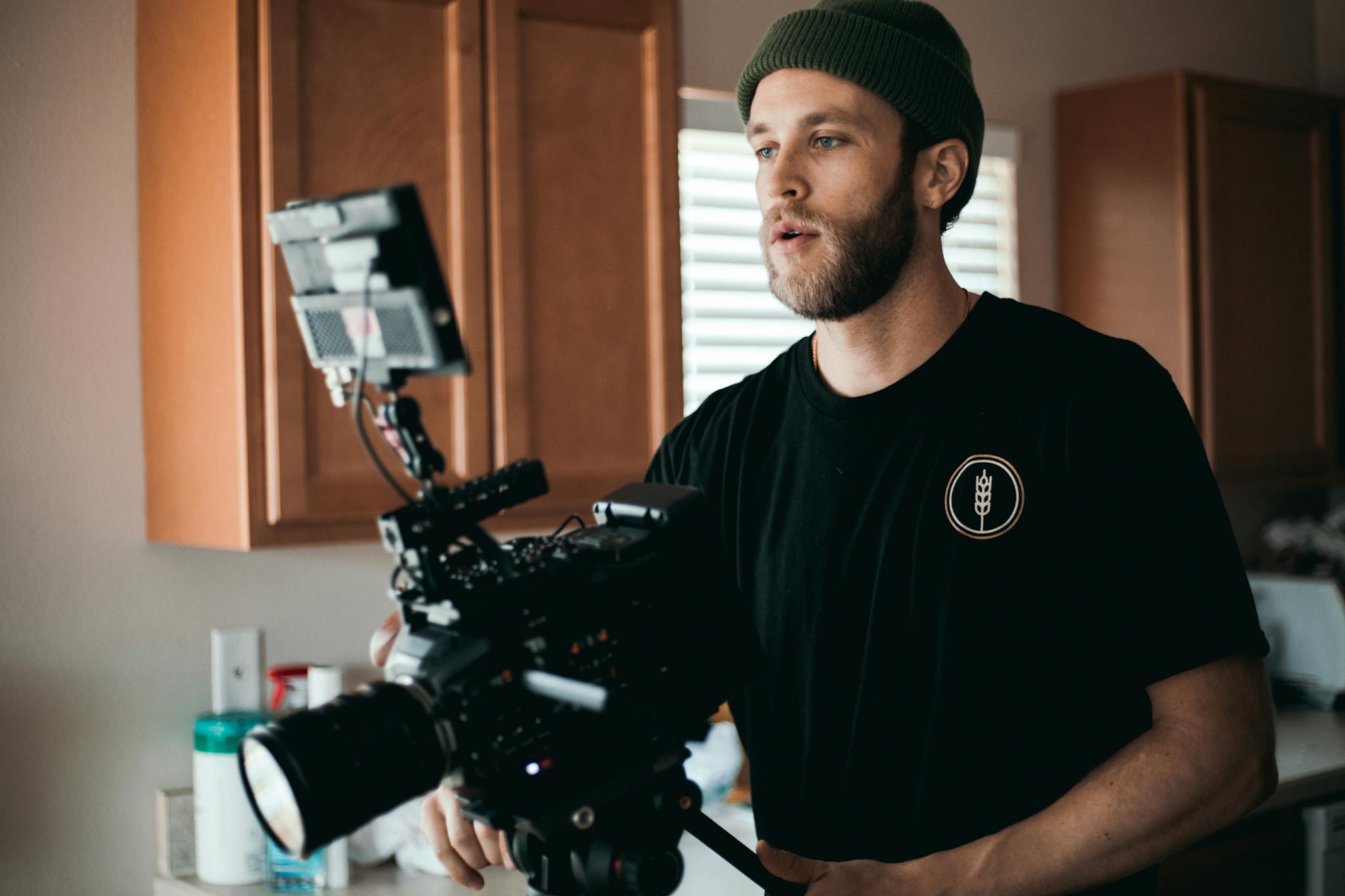 Man in Black Crew Neck T-shirt Using an Expensive Video Camera